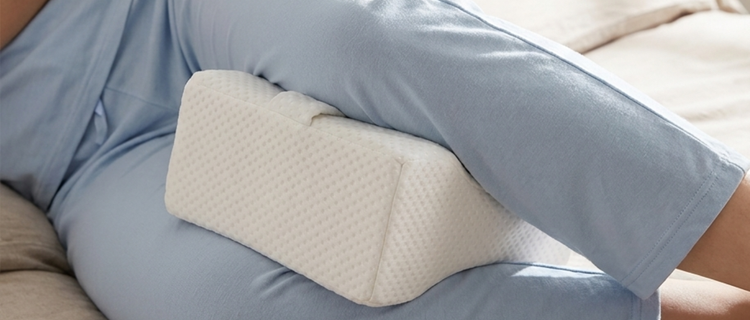 Memory foam knee pillow placed between legs during sleep  for hip and spine alignment — Home & Travel Gear Sleep  & Comfort collection